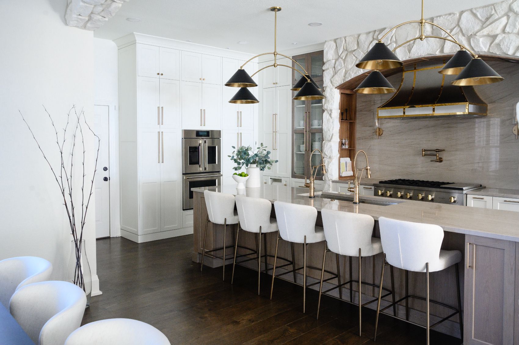 Mary Court kitchen with island seating under twin brass fixtures