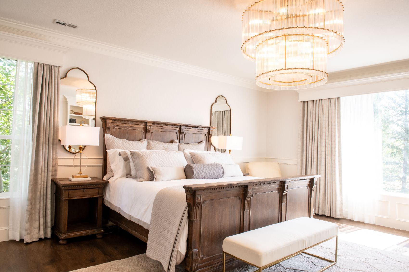 Mary Court primary bedroom with carved wood bed and fluted-glass chandeliers